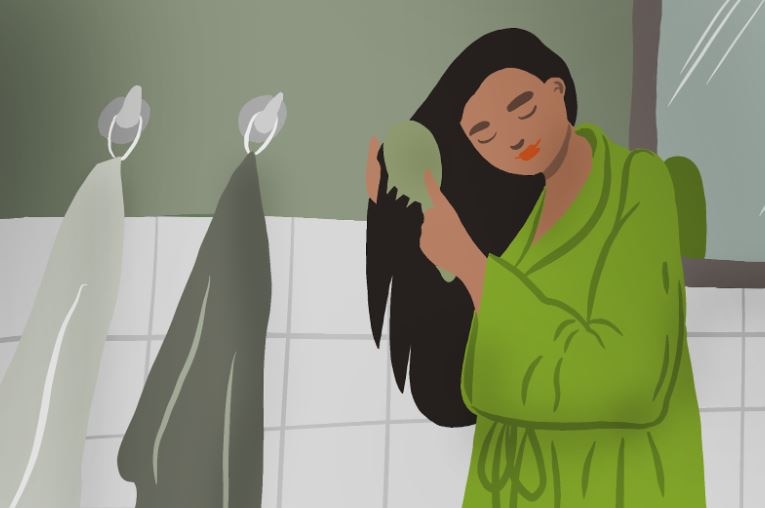a woman in bathrobe combing her silky hair