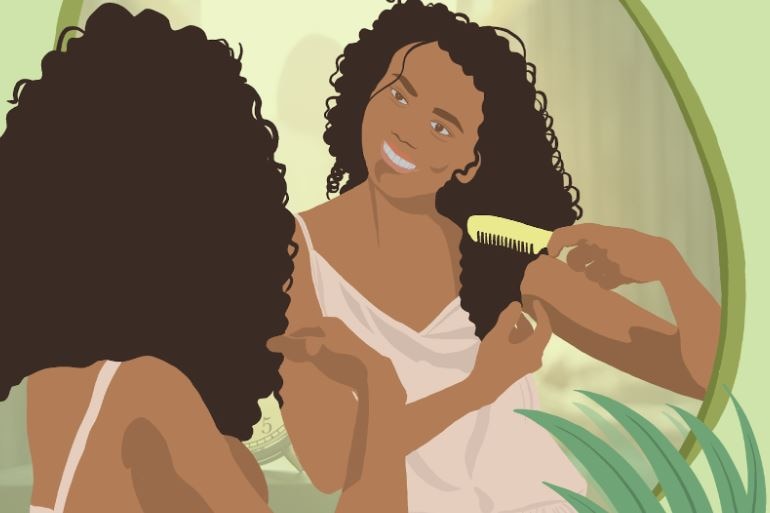 a woman combing her beautiful curly hair