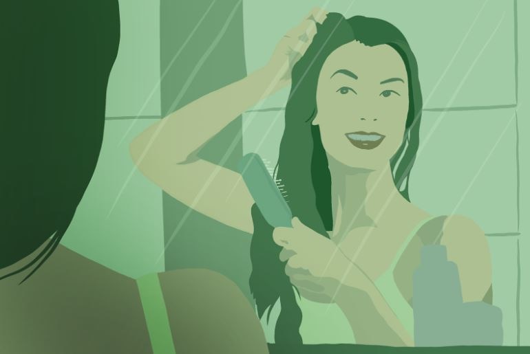 a woman checking her hair hair infron of a mirror